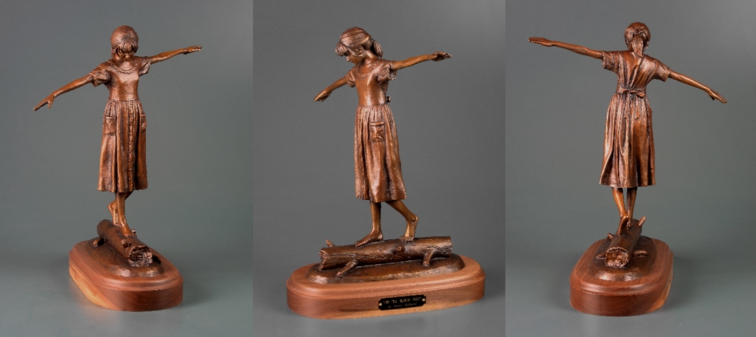 sculpture of girl walking on log